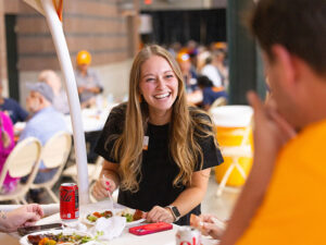 Two employees enjoy a conversation over an outdoor meal.