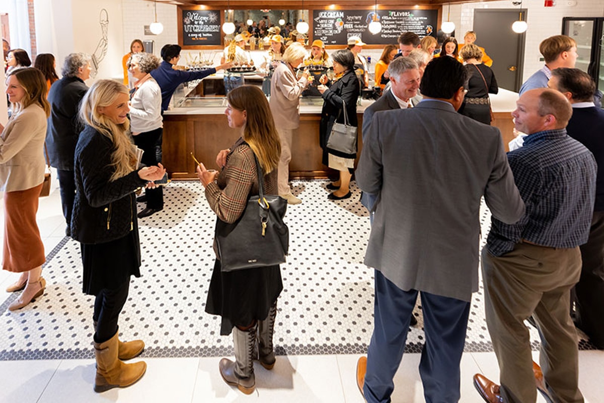 a large group of staff talk in smaller groups at the UT Creamery