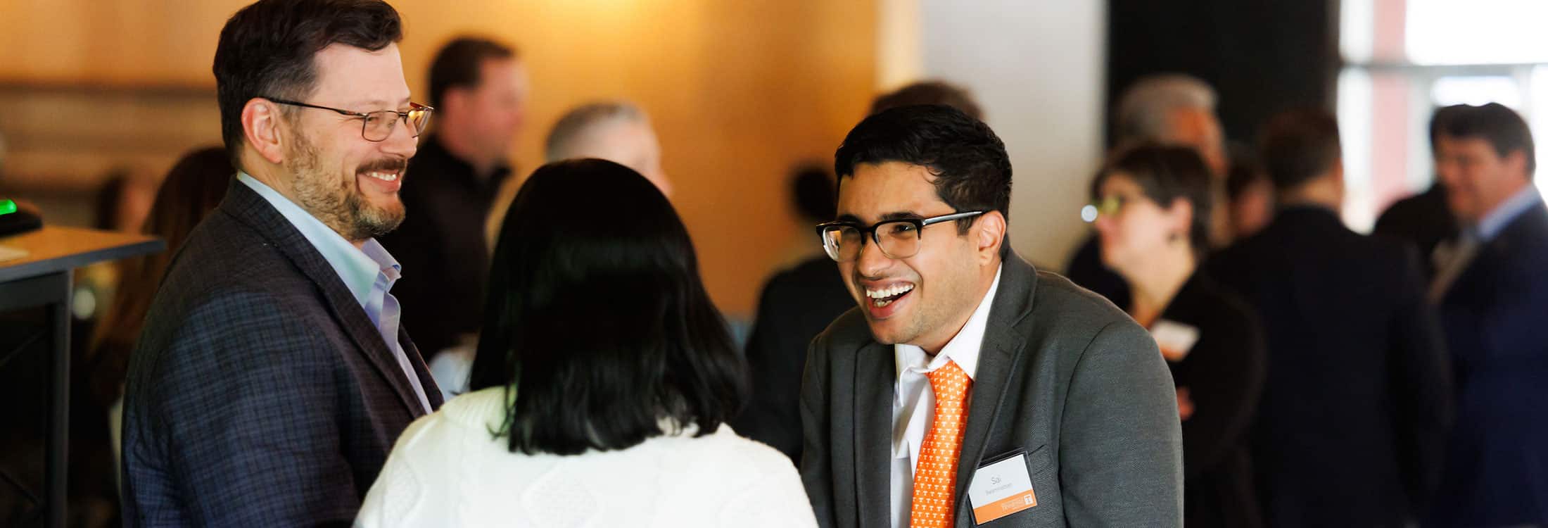 three individuals speak to each other in a group setting